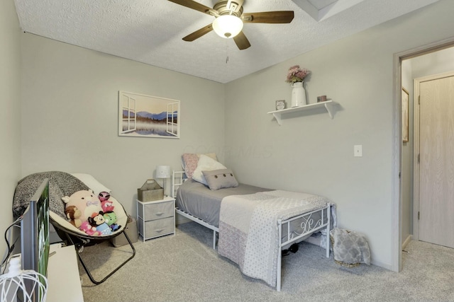 bedroom with ceiling fan, light carpet, and a textured ceiling