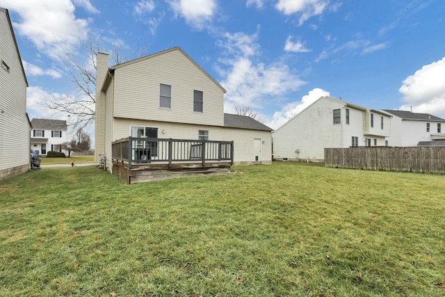 rear view of house featuring a deck and a lawn