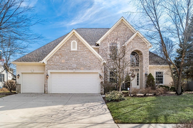 view of front of home with an attached garage, driveway, roof with shingles, stucco siding, and a front lawn