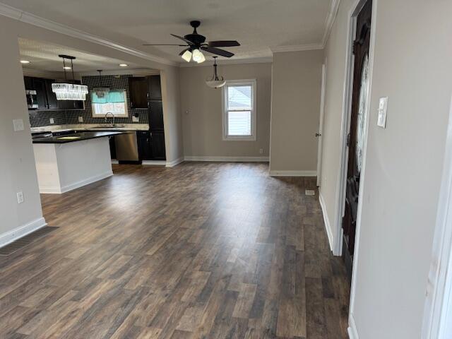 kitchen featuring dishwasher, sink, backsplash, ornamental molding, and dark wood-type flooring