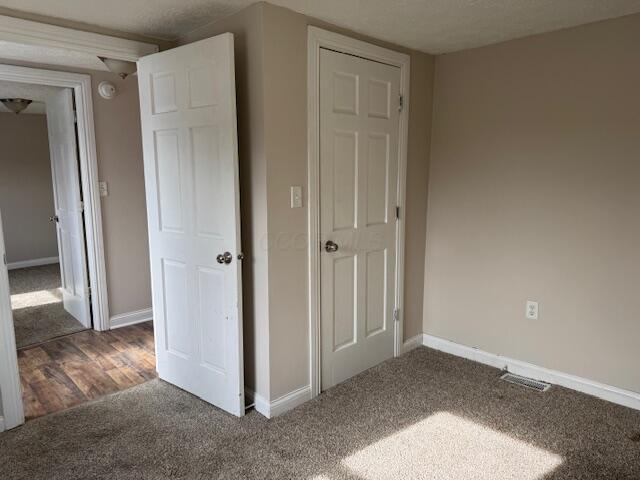 unfurnished bedroom featuring dark colored carpet