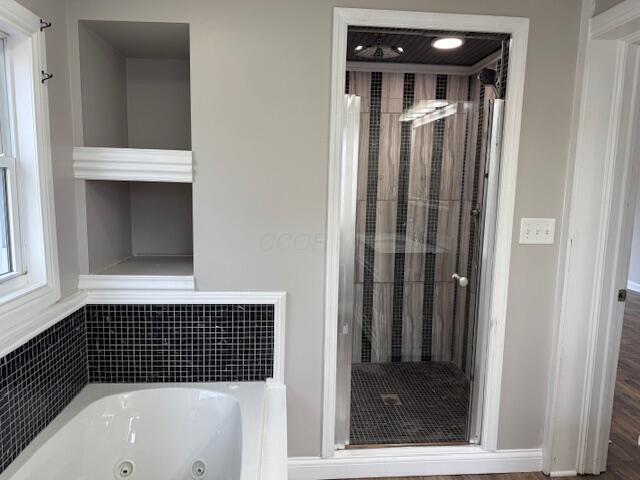 bathroom featuring hardwood / wood-style flooring and separate shower and tub