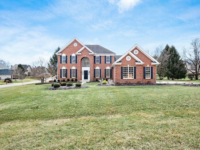 view of front of house featuring a front lawn and brick siding