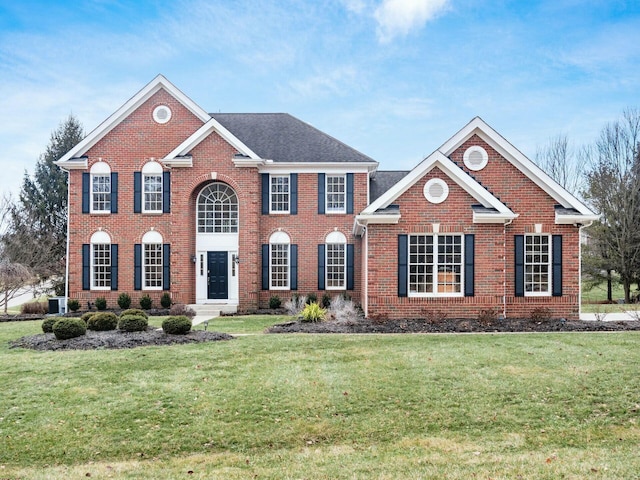 view of front of home featuring brick siding and a front yard