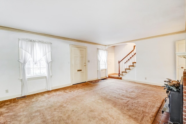 carpeted entryway with crown molding and a healthy amount of sunlight