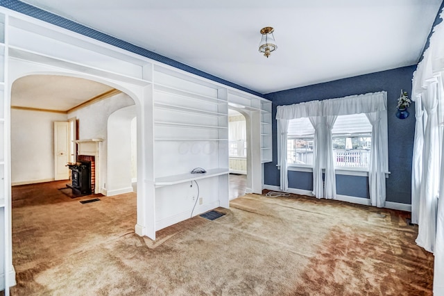 carpeted foyer entrance with a brick fireplace