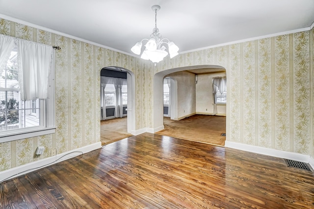 unfurnished dining area with hardwood / wood-style flooring, ornamental molding, and a chandelier