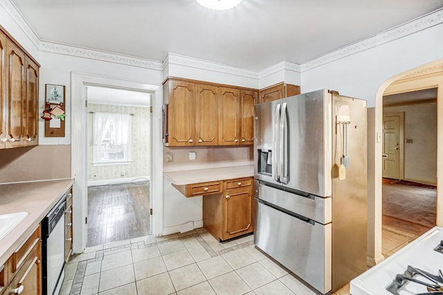 kitchen featuring stainless steel appliances, ornamental molding, and light hardwood / wood-style floors