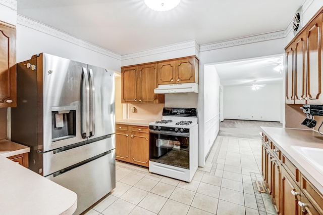 kitchen featuring light tile patterned floors, crown molding, ceiling fan, stainless steel refrigerator with ice dispenser, and range with gas cooktop