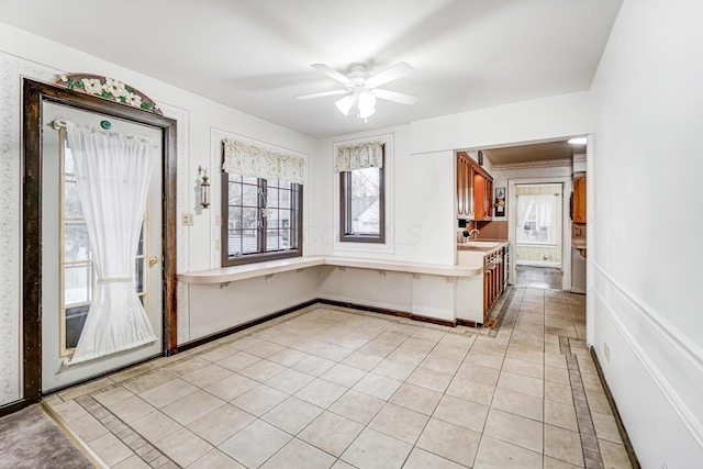 kitchen with light tile patterned flooring, sink, a wealth of natural light, and ceiling fan