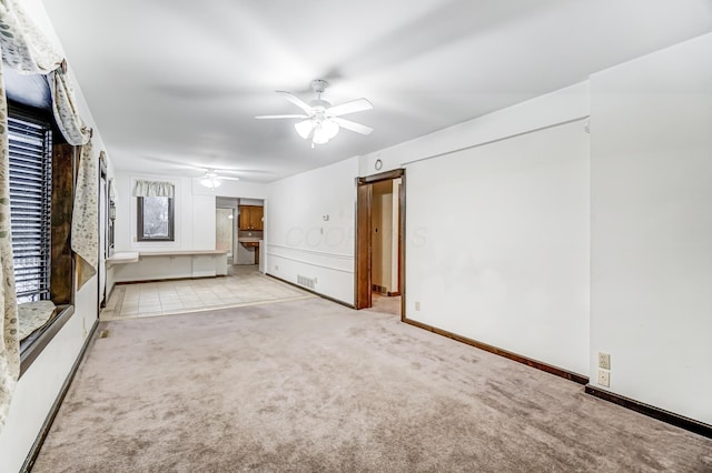 unfurnished living room featuring ceiling fan and light colored carpet