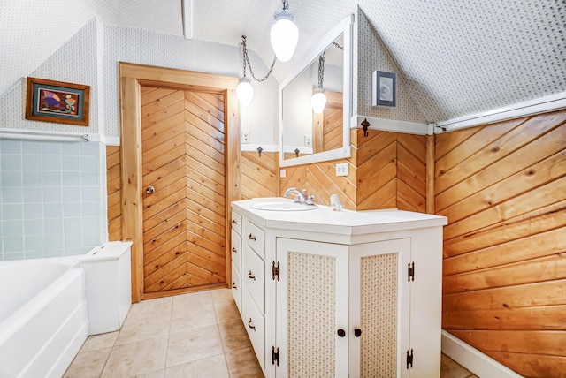 bathroom with tile patterned flooring, a bathing tub, and vanity