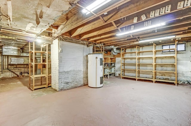 basement with electric water heater and brick wall