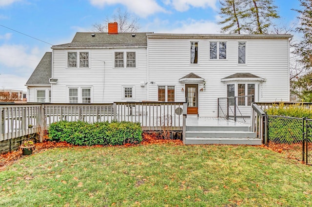 back of house with a wooden deck and a lawn