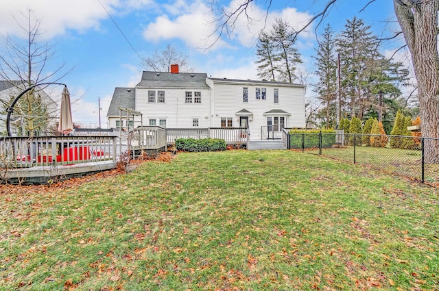 rear view of house featuring a yard and a deck