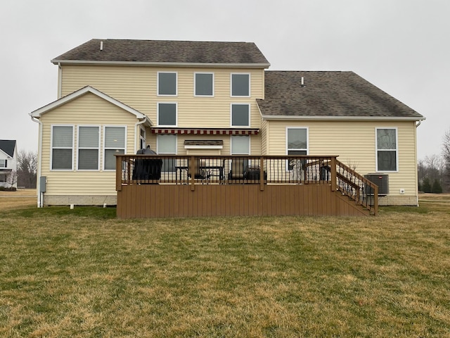 rear view of property with cooling unit, a deck, and a lawn