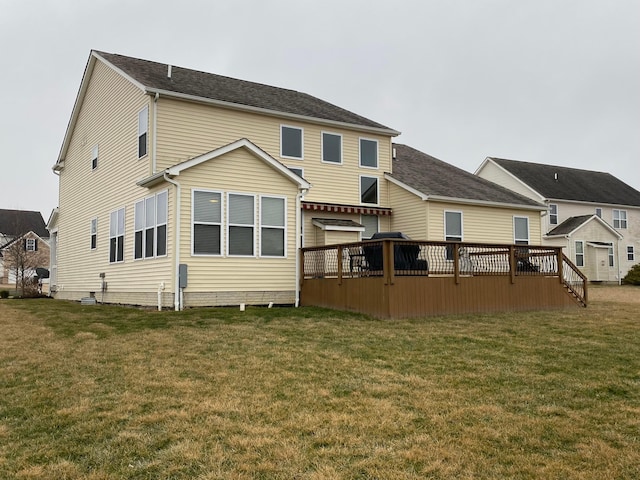 back of property with a deck and a lawn