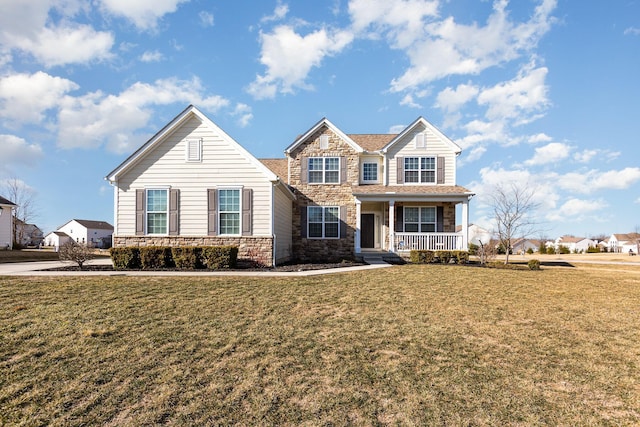 view of front of house featuring a front yard, covered porch, and stone siding