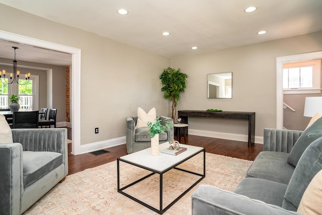 living room featuring dark wood-type flooring and a chandelier