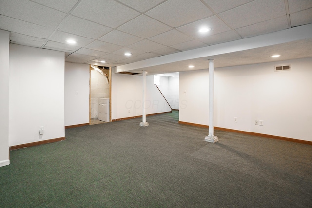 basement with dark carpet and a paneled ceiling