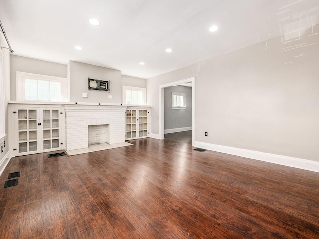 unfurnished living room with a fireplace and dark hardwood / wood-style floors