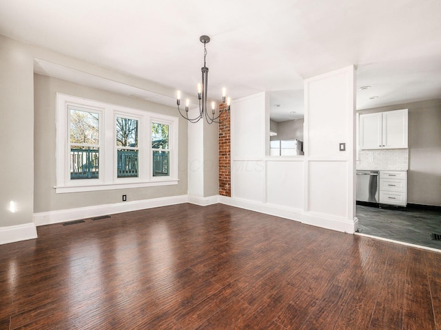 unfurnished dining area featuring dark wood-type flooring and a notable chandelier