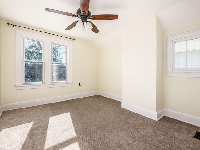 empty room with lofted ceiling, ceiling fan, and carpet flooring