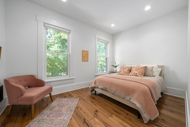 bedroom with hardwood / wood-style flooring and multiple windows