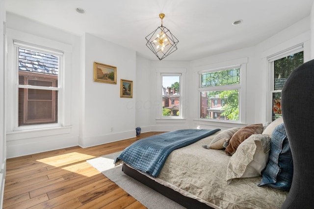 bedroom featuring an inviting chandelier and light wood-type flooring