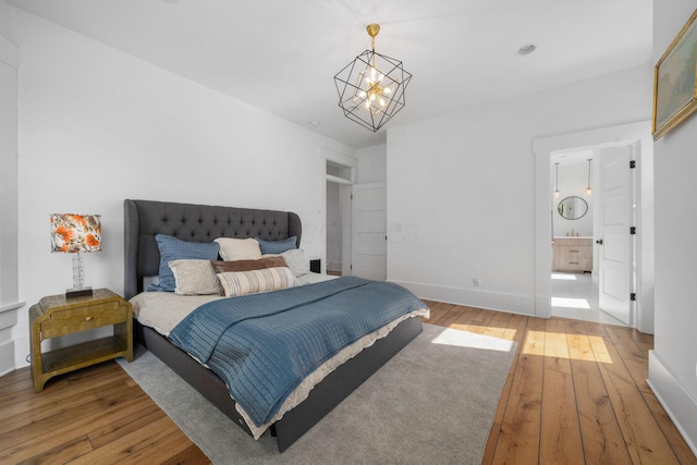 bedroom with an inviting chandelier and hardwood / wood-style floors