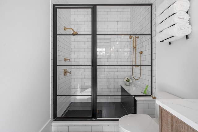 bathroom with vanity, an enclosed shower, and toilet