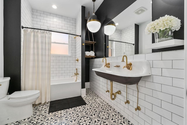 full bathroom with shower / tub combo, sink, tile patterned flooring, and tile walls