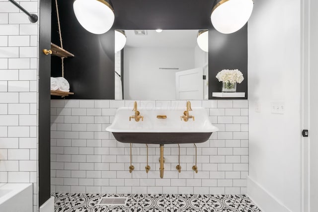 bathroom with sink and tile walls