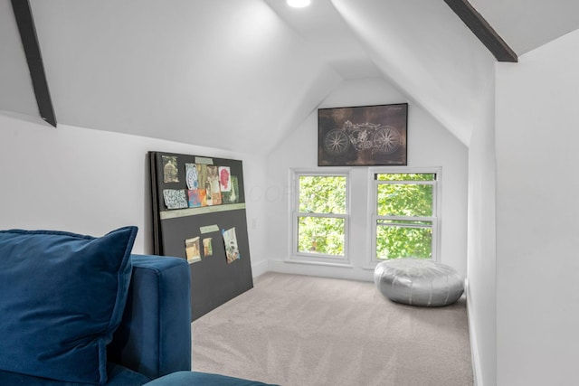 living area with vaulted ceiling with beams and light carpet