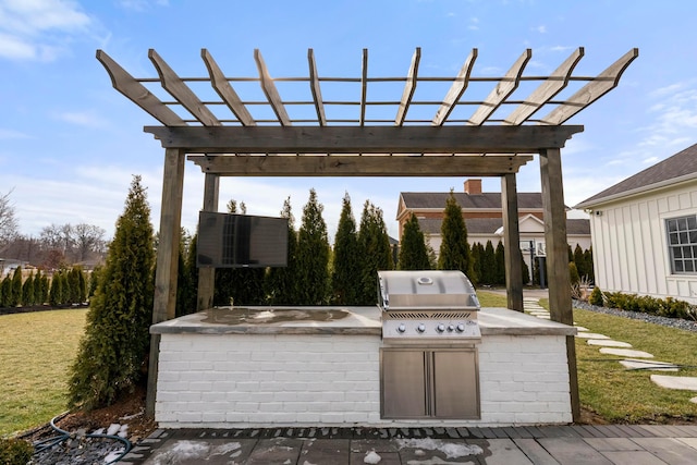 view of patio featuring area for grilling, a pergola, and an outdoor kitchen