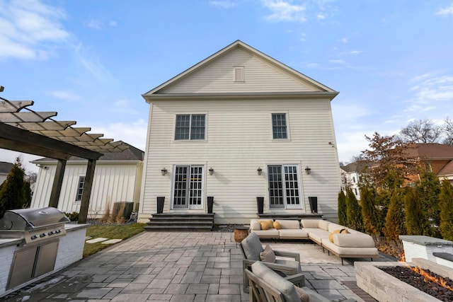 back of house with a pergola, a patio area, outdoor lounge area, and an outdoor kitchen