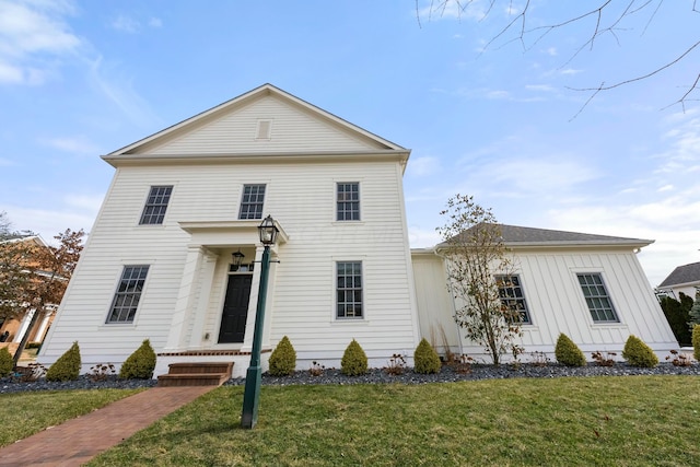 greek revival house featuring a front lawn