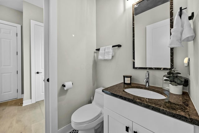 bathroom with vanity, hardwood / wood-style floors, and toilet