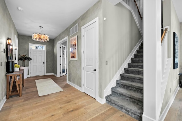 foyer with a chandelier and light hardwood / wood-style floors