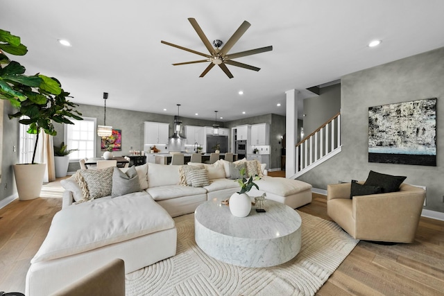 living room with ceiling fan and light hardwood / wood-style flooring