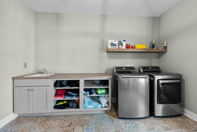 laundry area featuring independent washer and dryer, cabinets, and sink