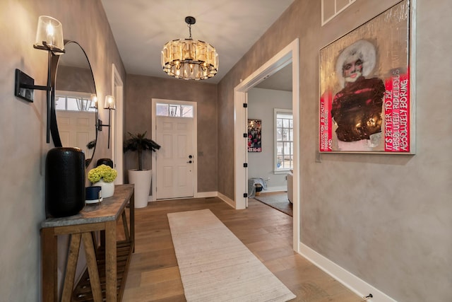 foyer featuring wood-type flooring and a chandelier