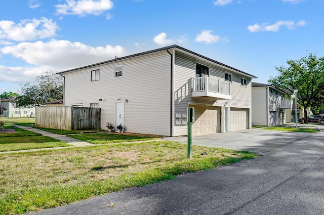 view of side of home with a balcony, a garage, and a yard