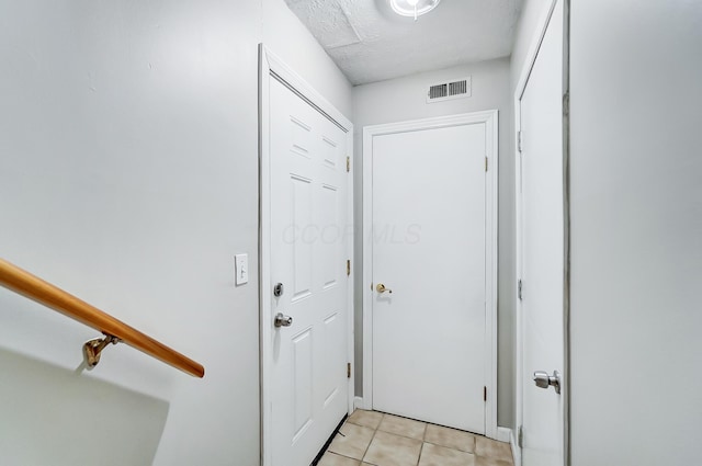 entryway featuring light tile patterned flooring and a textured ceiling