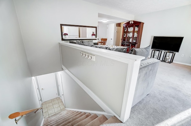 stairs featuring carpet and a textured ceiling