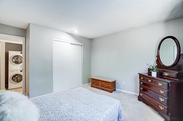 carpeted bedroom featuring a closet and stacked washing maching and dryer