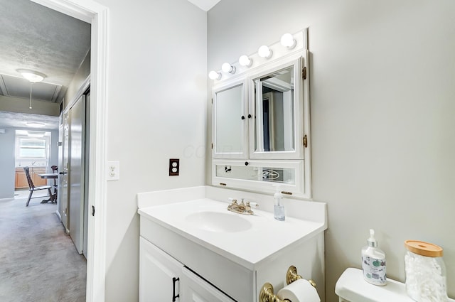 bathroom featuring vanity, a textured ceiling, and toilet