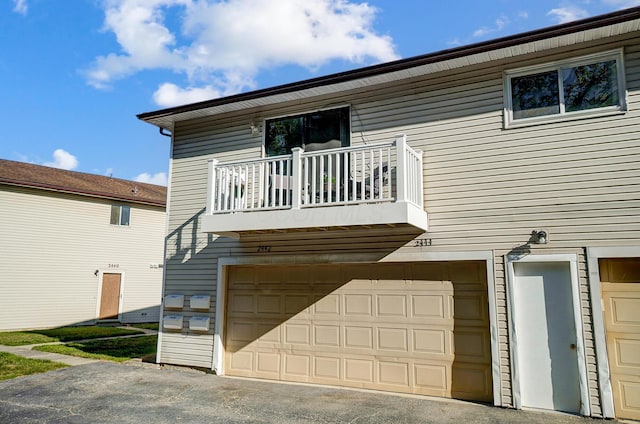 exterior space featuring a garage and a balcony