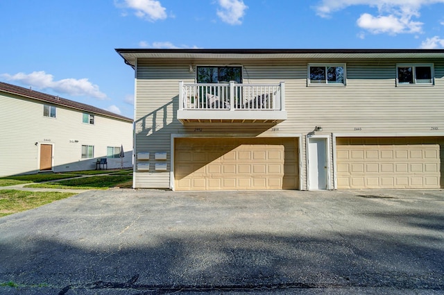 rear view of property featuring a garage and a balcony