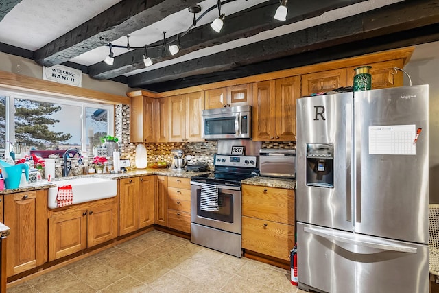 kitchen featuring sink, backsplash, beam ceiling, stainless steel appliances, and light stone counters